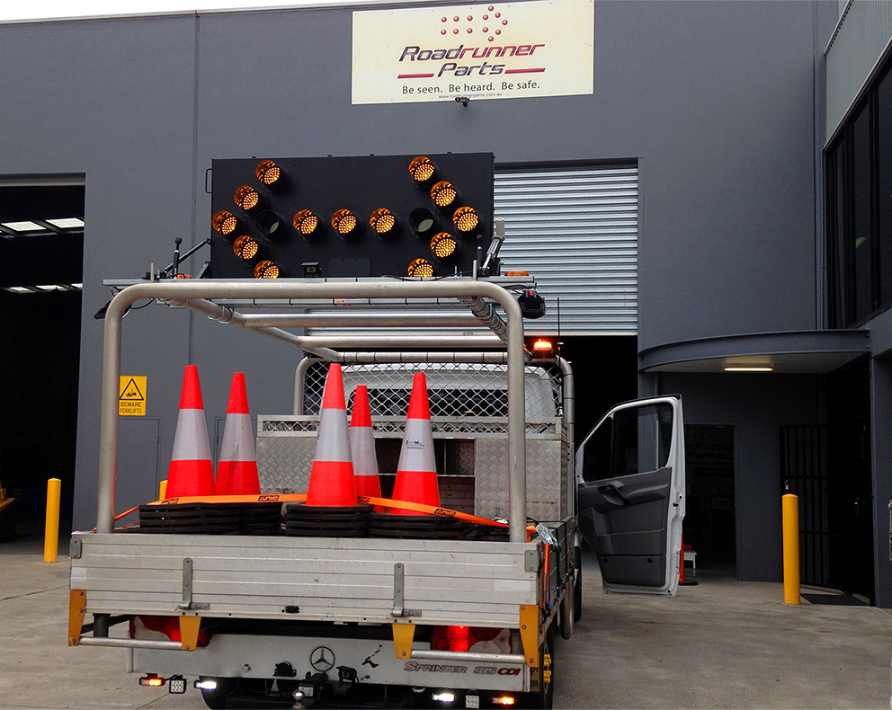 a truck carrying traffic cones and an arrow board